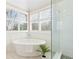 Bright bathroom showcasing a standalone tub, white subway tile shower, and natural light at 720 Lakeglen Dr, Suwanee, GA 30024
