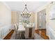 Elegant dining room with stylish chandelier, wainscoting, and wood floors at 720 Lakeglen Dr, Suwanee, GA 30024