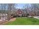 Frontal exterior view of home features a verdant lawn and mature trees at 720 Lakeglen Dr, Suwanee, GA 30024