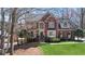 Beautiful two-story red brick home with arched window and manicured lawn at 720 Lakeglen Dr, Suwanee, GA 30024