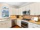 Charming eat-in kitchen with stainless steel appliances and granite countertops at 720 Lakeglen Dr, Suwanee, GA 30024