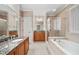 Well-lit bathroom featuring double vanity, soaking tub, and separate glass shower at 8215 Majors Mill Dr, Cumming, GA 30041