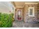 Charming front entrance with stone facade, brick paver path, and a decorative glass front door at 8215 Majors Mill Dr, Cumming, GA 30041