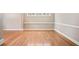 Open living room featuring hardwood floors, crown moulding, and large windows at 8215 Majors Mill Dr, Cumming, GA 30041