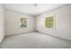 Minimalist bedroom with neutral carpet, two windows offering natural light, and white walls at 1715 E Clifton Ne Rd, Atlanta, GA 30307