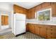 Cozy kitchen featuring wood cabinets, a white refrigerator, and a window with views of the trees at 1715 E Clifton Ne Rd, Atlanta, GA 30307