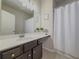 This bathroom has a modern vanity with a white countertop and sleek fixtures, and a shower with a white curtain at 262 Quay Dr, Lawrenceville, GA 30044