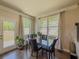 Bright dining area with hardwood floors, large windows, and elegant glass table, perfect for gatherings at 262 Quay Dr, Lawrenceville, GA 30044