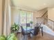 Bright dining area with a glass table, hardwood floors, and a large window offering natural light and outdoor views at 262 Quay Dr, Lawrenceville, GA 30044