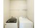 The functional laundry room is equipped with a modern washer and dryer, and features a convenient storage shelf above at 262 Quay Dr, Lawrenceville, GA 30044