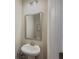 Cozy powder room featuring a pedestal sink, modern lighting, and a stylish mirror for a touch of elegance at 262 Quay Dr, Lawrenceville, GA 30044