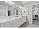 Bathroom with double vanity, white cabinets, and a large mirror reflecting the bedroom at 400 Mirramont Ln, Woodstock, GA 30189