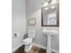 Bathroom features a pedestal sink, decorative mirror, and gray walls at 400 Mirramont Ln, Woodstock, GA 30189