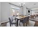 Bright dining area with backyard access, chandelier and comfortable gray chairs at 400 Mirramont Ln, Woodstock, GA 30189