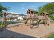A wooden playground with swings and slides is surrounded by grass and trees at 400 Mirramont Ln, Woodstock, GA 30189