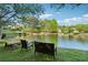 Beautiful view of the pond with seating and mature trees around the bank at 400 Mirramont Ln, Woodstock, GA 30189
