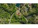 Overhead shot of house with a red roof surrounded by dense trees and greenery, near 2 small lakes at 6515 Namon Wallace Dr, Cumming, GA 30028