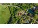 Aerial image of a property surrounded by trees, featuring a red-roofed house, lake and green lawns at 6515 Namon Wallace Dr, Cumming, GA 30028