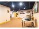 This finished basement area features a black drop ceiling, storage shelves, and a round table at 6515 Namon Wallace Dr, Cumming, GA 30028