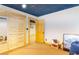 Finished basement features wood trim and an open layout with a view of a closet with louvered doors at 6515 Namon Wallace Dr, Cumming, GA 30028