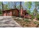 Charming log home with an attached garage, flag and a cozy front porch nestled among mature trees at 6515 Namon Wallace Dr, Cumming, GA 30028