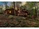 Inviting log home featuring a cozy front porch with evening lights among mature trees at 6515 Namon Wallace Dr, Cumming, GA 30028