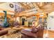 Inviting living room features wood beams, wood-burning fireplace, and views into the kitchen at 6515 Namon Wallace Dr, Cumming, GA 30028