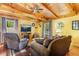 Cozy living room with wooden ceiling, comfortable seating, and a view of the outdoors through the windows at 6515 Namon Wallace Dr, Cumming, GA 30028