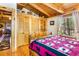Inviting main bedroom with exposed beams, a quilt bed, and a view of wooded scenery at 6515 Namon Wallace Dr, Cumming, GA 30028