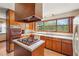 Traditional kitchen featuring wood cabinets, a gas stovetop island, and a large window overlooking the yard at 1735 Little Willeo Rd, Marietta, GA 30068