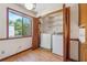 Bright laundry room features a washer, a dryer, storage shelves, and a window with a view to the outside at 1735 Little Willeo Rd, Marietta, GA 30068