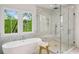 Luxurious bathroom with a soaking tub, walk-in glass shower, and a serene view from the bright window at 2193 Virginia Ne Pl, Atlanta, GA 30305