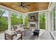 Covered outdoor living space with a stone fireplace, comfortable seating, and a wood-paneled ceiling at 2193 Virginia Ne Pl, Atlanta, GA 30305