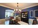 Stylish dining room featuring a modern chandelier, blue accent wall, and elegant furniture at 2227 Austin Lake Se Dr, Smyrna, GA 30082