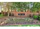 Community entrance featuring brick sign, manicured landscaping, and mulched flower beds at 2227 Austin Lake Se Dr, Smyrna, GA 30082