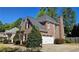 Charming brick home featuring an attached garage, mature trees, and manicured landscaping at 2227 Austin Lake Se Dr, Smyrna, GA 30082