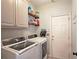 Functional laundry room with washer, dryer, upper cabinets, and access to an exterior door at 2227 Austin Lake Se Dr, Smyrna, GA 30082