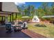 Beautiful backyard with a patio featuring outdoor fireplace, dining, seating and manicured landscaping at 3920 Maybreeze Rd, Marietta, GA 30066