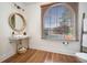Bathroom featuring a vanity sink with a round mirror and an arched window at 3920 Maybreeze Rd, Marietta, GA 30066