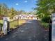 Stately white home with wood trim, garage, and automatic gate on long asphalt driveway at 3920 Maybreeze Rd, Marietta, GA 30066