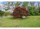 View of the backyard with a Japanese maple tree and wrought iron bench creating a serene outdoor space at 3920 Maybreeze Rd, Marietta, GA 30066
