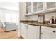 Convenient bar area featuring granite countertops, white cabinets, and glass shelves for storing beverages and accessories at 272 Rumson Ne Rd, Atlanta, GA 30305