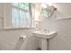 Classic white bathroom showcasing a pedestal sink, tile floors, and a window at 272 Rumson Ne Rd, Atlanta, GA 30305