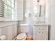 Elegant powder room featuring striped wallpaper, a pedestal sink, and a framed mirror at 272 Rumson Ne Rd, Atlanta, GA 30305