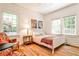 Bright bedroom features hardwood floors, a white bed frame, and multiple windows at 272 Rumson Ne Rd, Atlanta, GA 30305