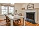 Dining room features hardwood floors, a fireplace, white table, and views to the backyard at 272 Rumson Ne Rd, Atlanta, GA 30305