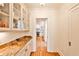 Hallway features a marble counter with glass front cabinets, hardwood floors, and white walls at 272 Rumson Ne Rd, Atlanta, GA 30305