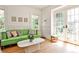 Sunlit living room with a green sofa, elegant wainscoting, and charming French doors leading to the outdoors at 272 Rumson Ne Rd, Atlanta, GA 30305