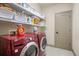 Functional laundry room featuring red front-load washer and dryer set with shelving at 3739 Union Park Dr, Duluth, GA 30097