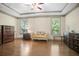 Sun-filled main bedroom with tray ceilings, hardwood floors, and seating area with large windows at 3739 Union Park Dr, Duluth, GA 30097